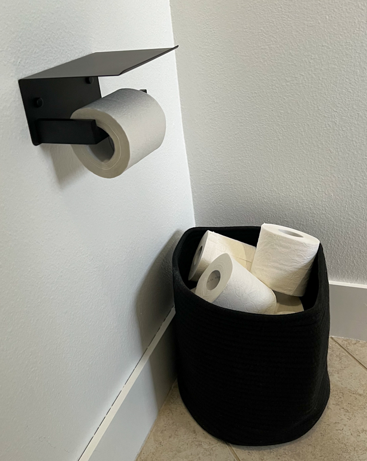 replacing toilet paper holder with a modern one including a phone rest along with a basket
