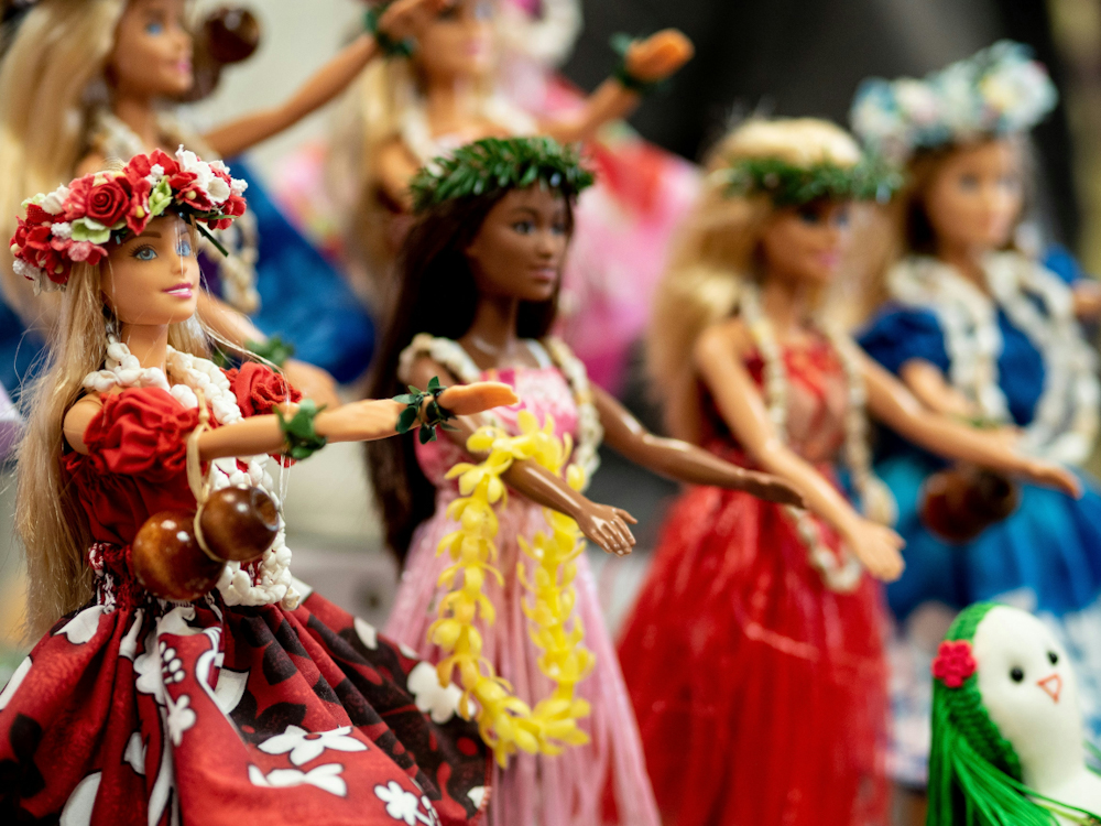 Barbie dolls lined up all dressed in Hawaiian inspired outfits