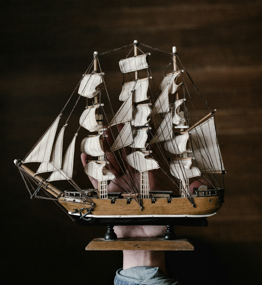 A toy pirate ship being held in a child's hand