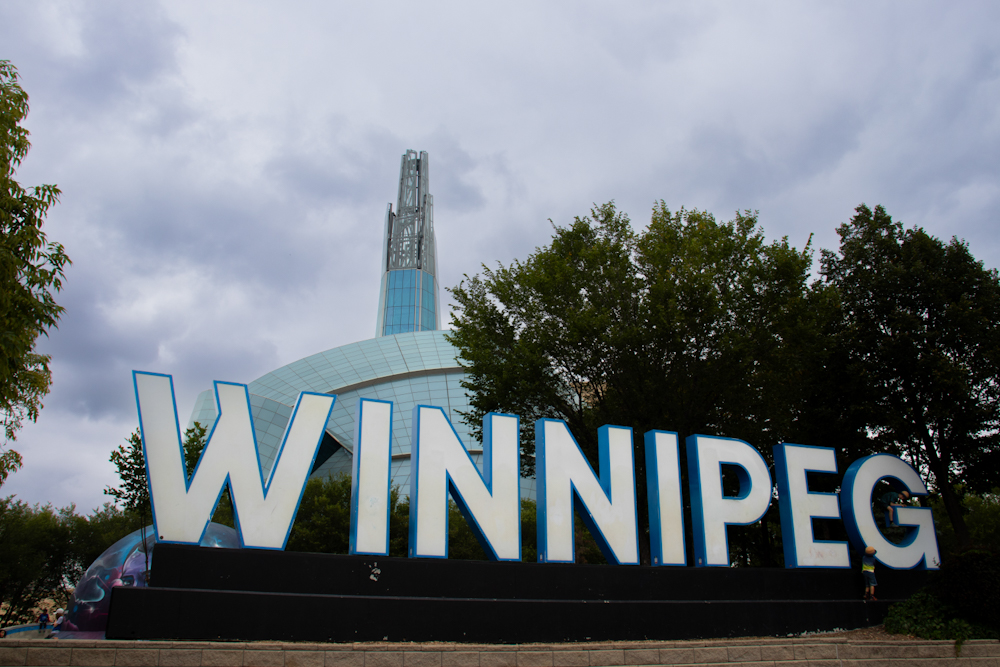 the Winnipeg sign with the Canadian Museum for Human Rights in the background