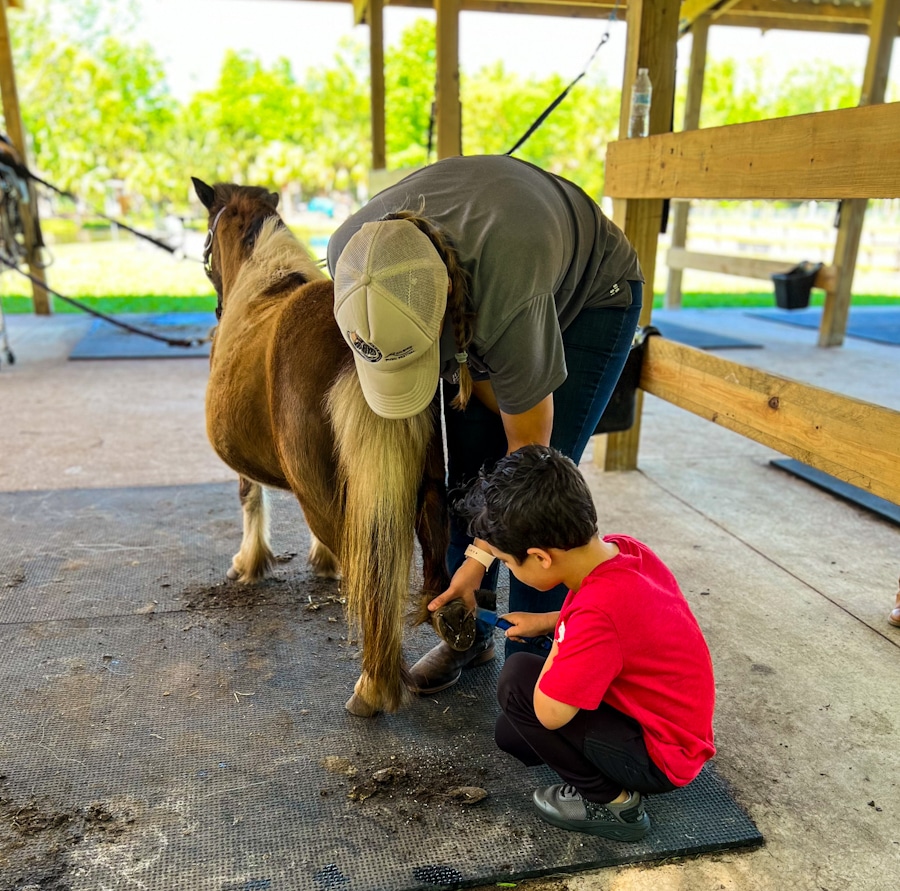 kid cleaning out a horseshoe at Hidden Palms Ranch in Sanford, Florida