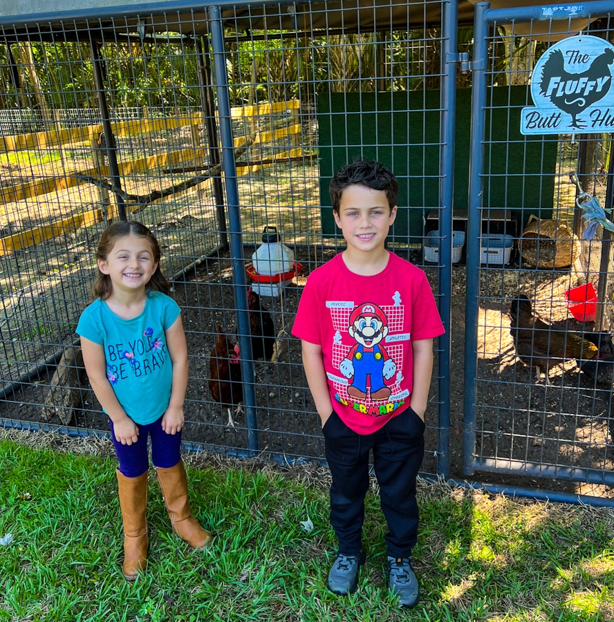 2 kids in front of a chicken coop at Hidden Palms Ranch in Sanford, Florida