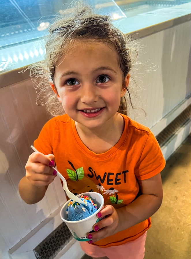 little girl eating blue ice cream from at one of the restaurants in Sanford Florida, The Greenery Creamery
