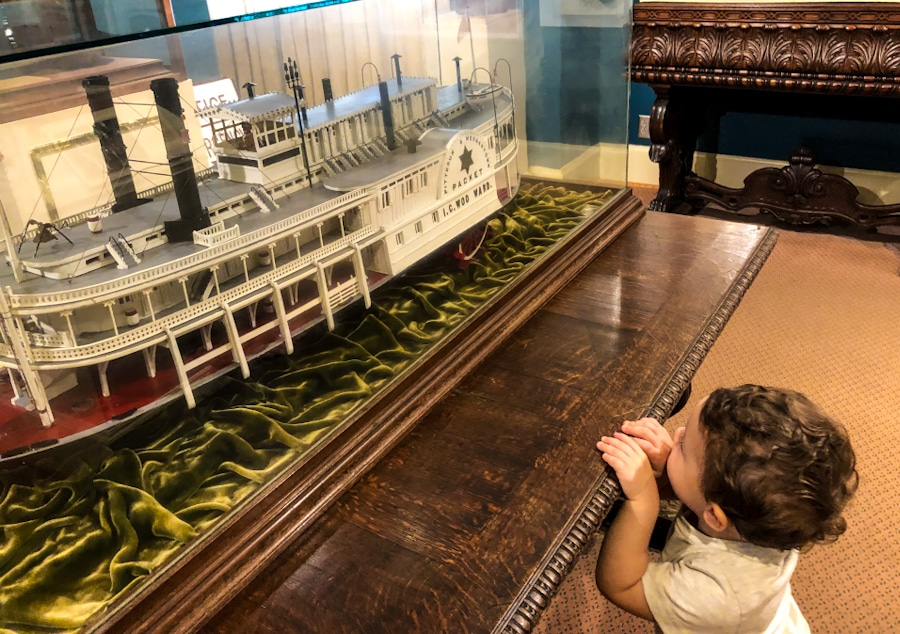 small child looking at a paddleboat exhibit at the Lightner Museum in St Augustine Florida