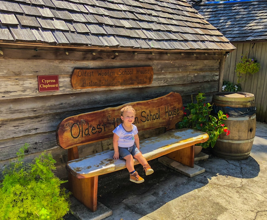 small child sitting on a bench at the Oldest Wooden Schoolhouse Museum in St Augustine Florida