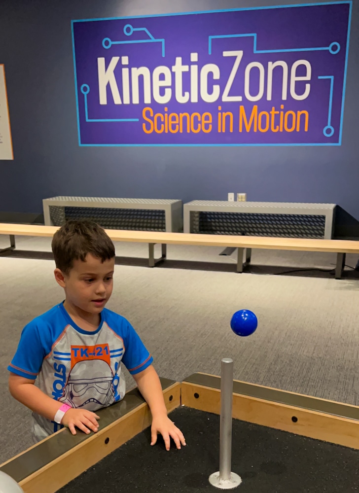 toddler boy watching a ball levitate at the Kinetic Zone of the Orlando Science Center