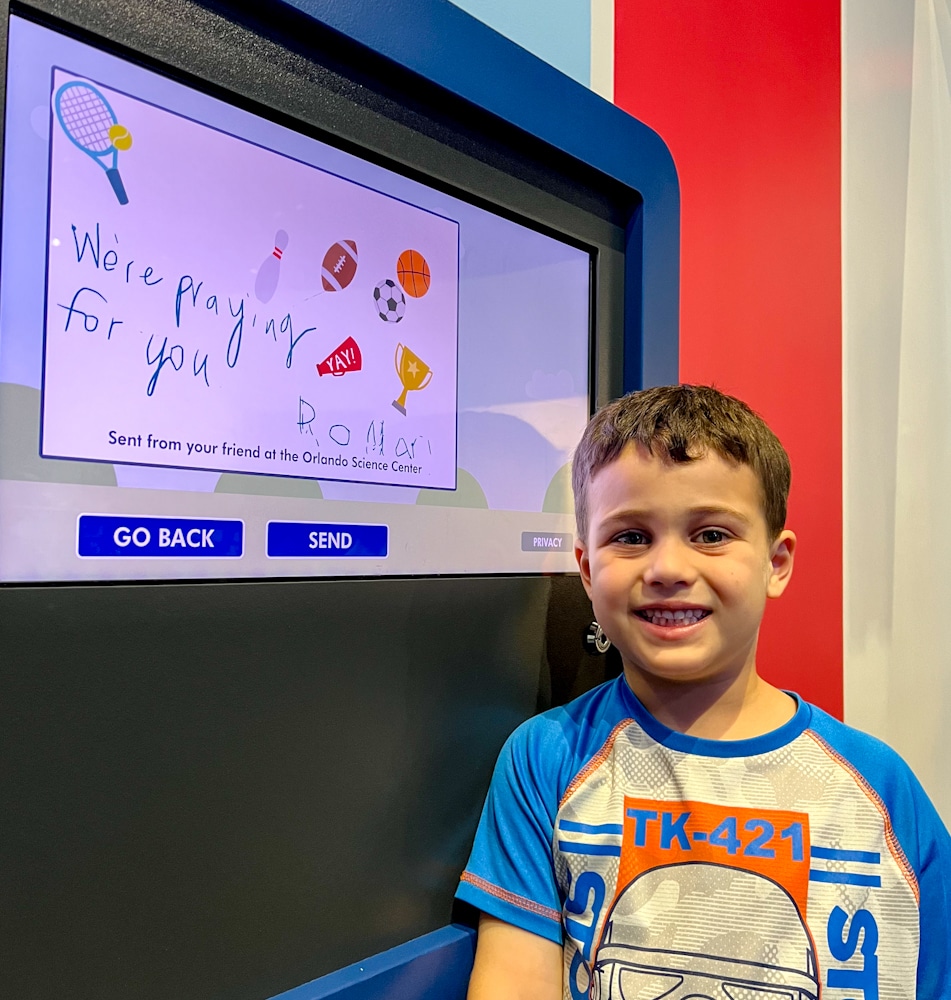 little boy in front of his drawing at the Orlando Science Center