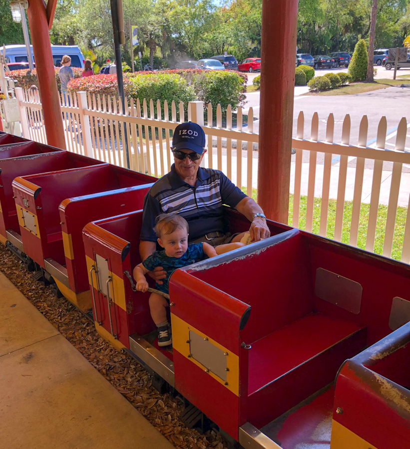 My son and his grandpa riding the little train at Central Florida Zoo & Botanical Gardens