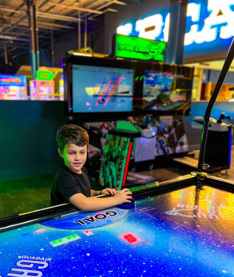 My son playing air hockey at Elev8 Fun Sanford. One of the fun things to do in Sanford Florida.