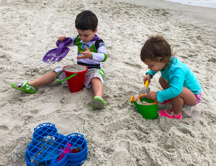 kids playing in the sand with beach toys