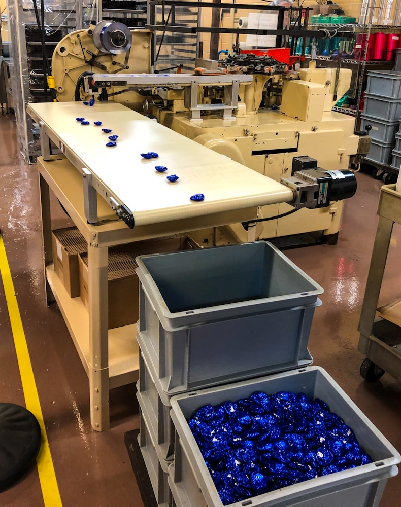 conveyor belt with blue wrapped chocolate in a chocolate factory